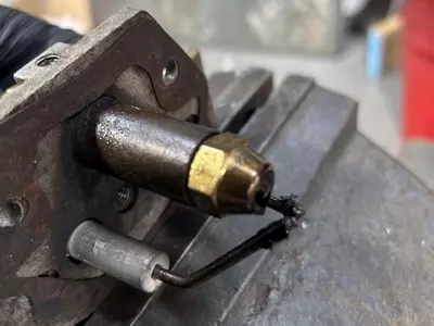 Old and worn burner electrodes on Edge Panther pressure washer showing carbon buildup prior to replacement.